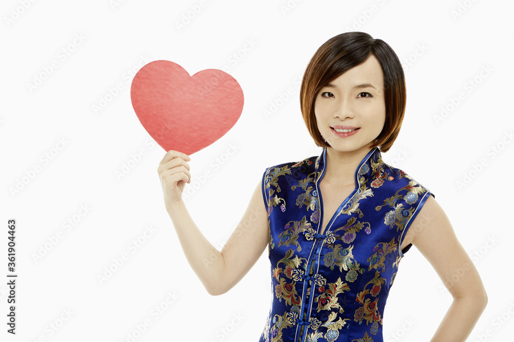Woman in traditional clothing holding up a red heart Woman in traditional clothing holding up a red heart