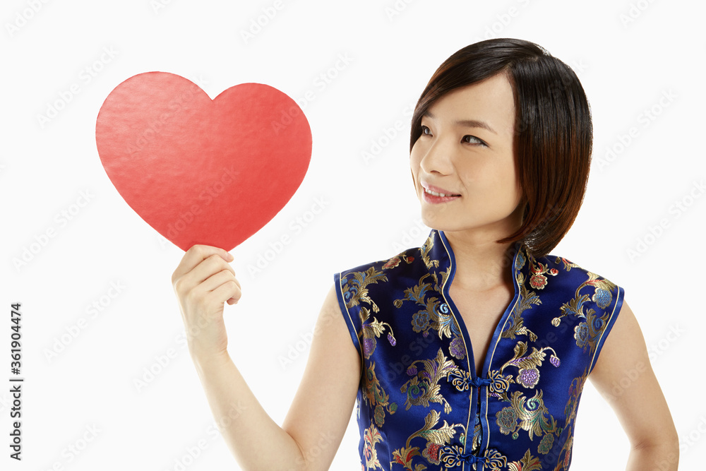 Woman in traditional clothing holding up a red heart Woman in traditional clothing holding up a red heart