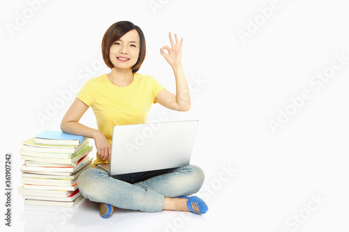 Woman with laptop showing hand gesture © ImageHit