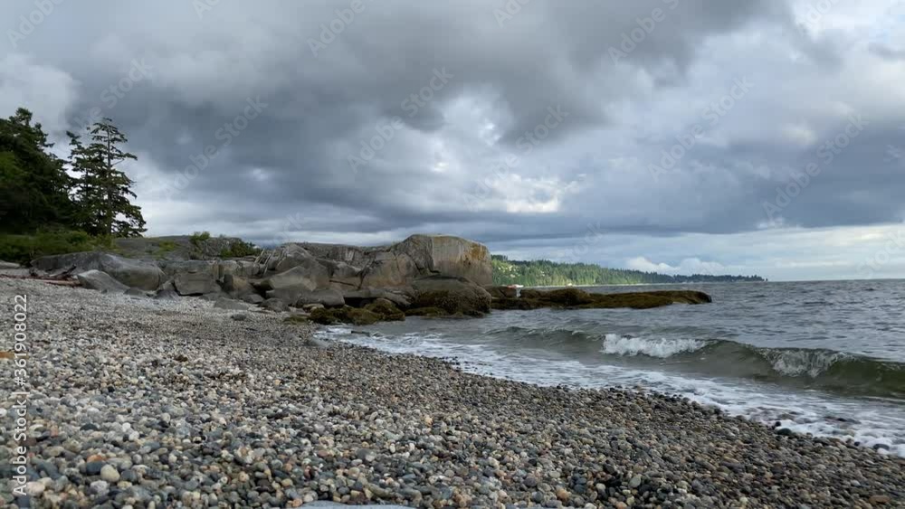 Ocean beach with rocks, pebbles and waves at summer day with dramatic clouds. Ocean beach with rocks, pebbles and waves at summer day with dramatic clouds.