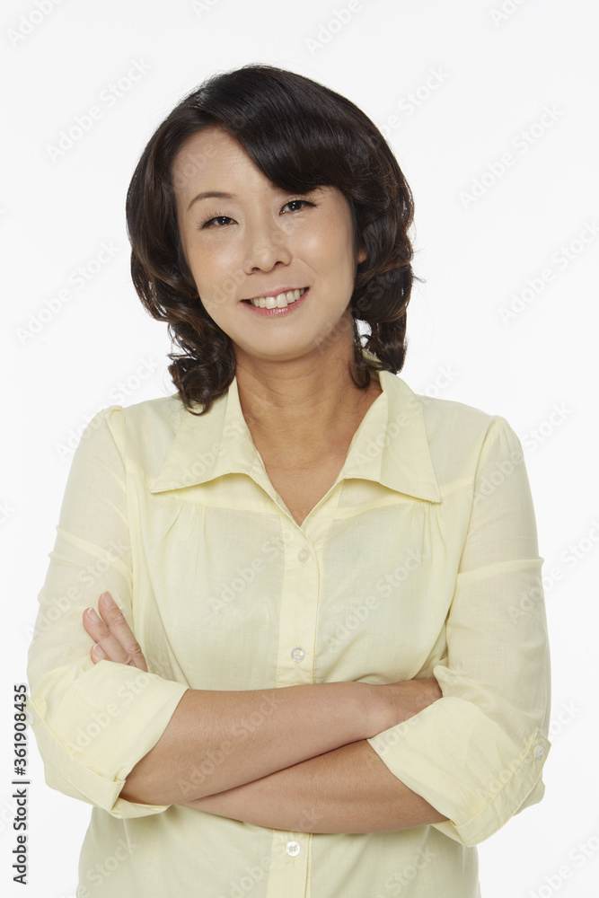 Woman standing with arms crossed, smiling Woman standing with arms crossed, smiling