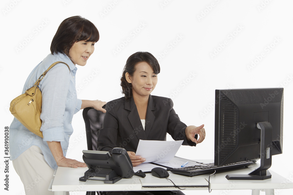 Businesswoman showing customer information on the computer screen Businesswoman showing customer information on the computer screen