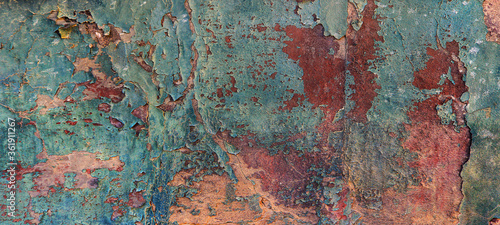 artistic abstract rugh texture background of a blue, red, orange and green wall with peeling paint and chipped - punk wallpaper
