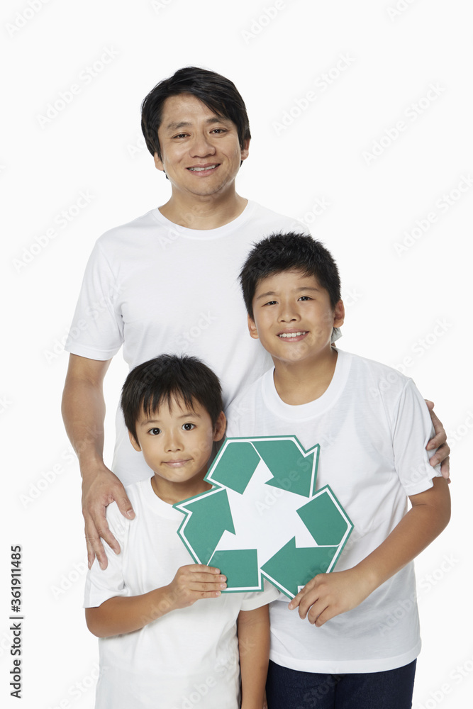 Family of three smiling and holding up a Recycle logo Family of three smiling and holding up a Recycle logo
