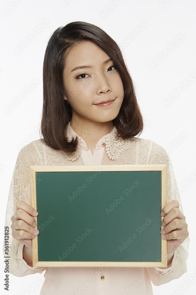 Cheerful woman holding up a blank blackboard Cheerful woman holding up a blank blackboard