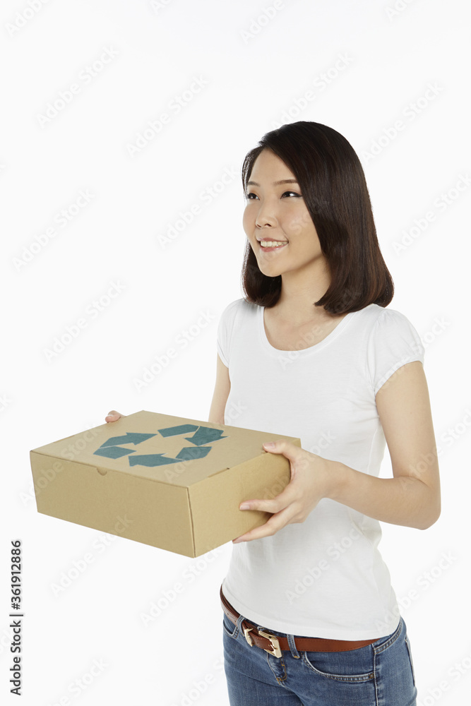 Cheerful woman carrying a recyclable cardboard box Cheerful woman carrying a recyclable cardboard box