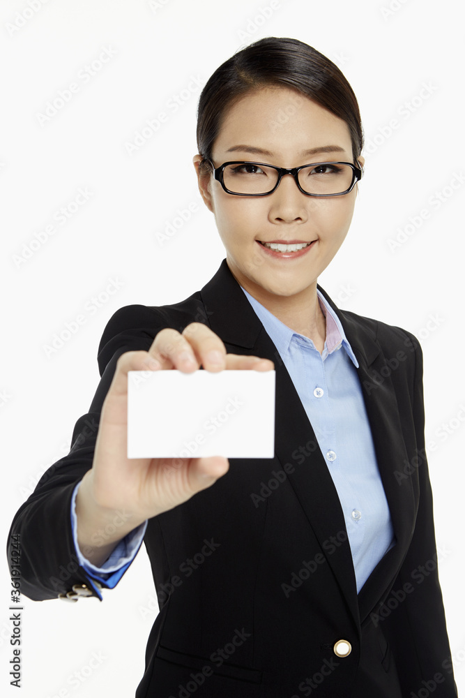 Cheerful businesswoman holding up a blank business card Cheerful businesswoman holding up a blank business card