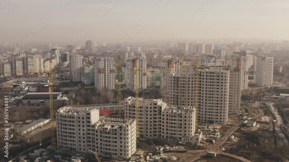 Aerial approaching shot of the construction of new buildings for housing, office buildings and construction yellow cranes in the city Kharkov, Ukraine. Top view of construction multi-storey buildings. Aerial approaching shot of the construction of new buildings for housing, office buildings and construction yellow cranes in the city Kharkov, Ukraine. Top view of construction multi-storey buildings.