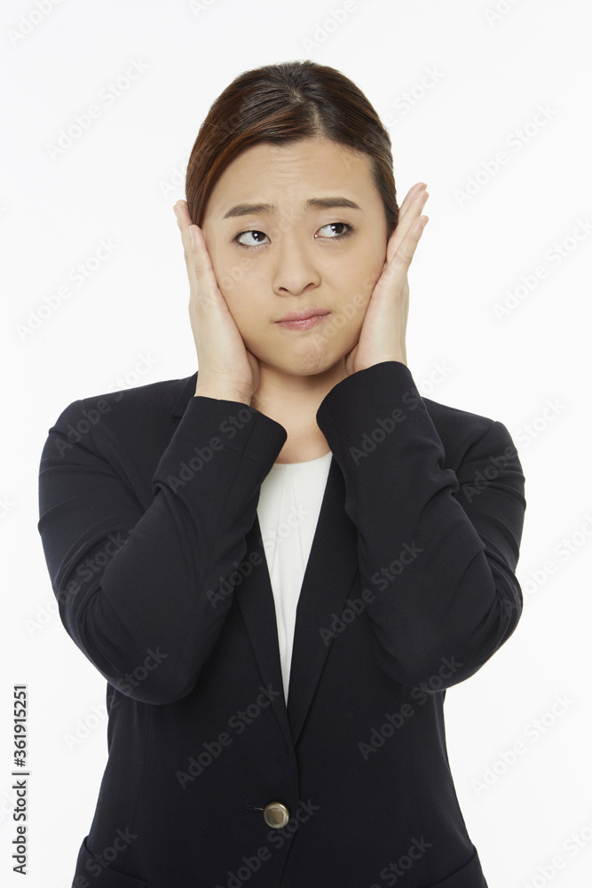 Businesswoman covering her ears Businesswoman covering her ears