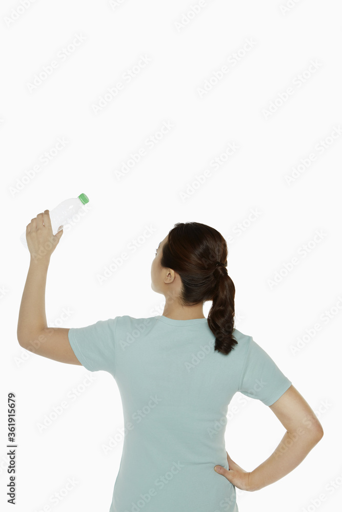 Woman holding up a plastic bottle Woman holding up a plastic bottle