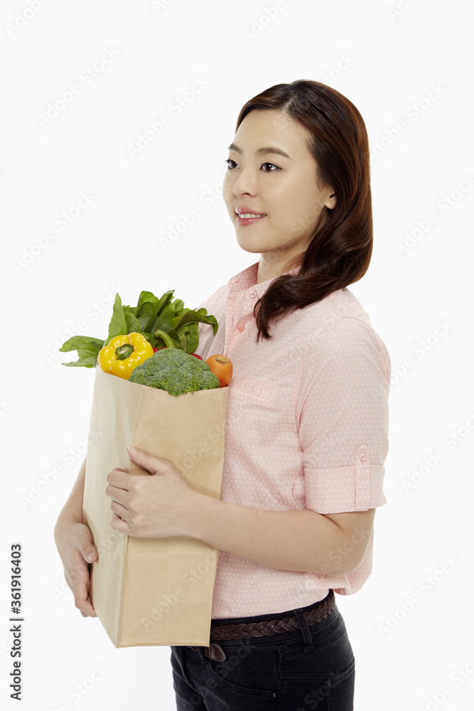 Cheerful woman with a bag of groceries