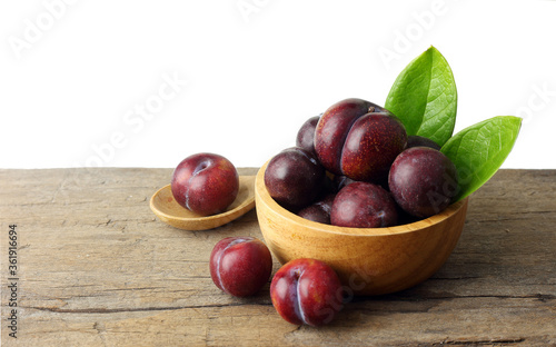 Fresh plum on wooden table against white