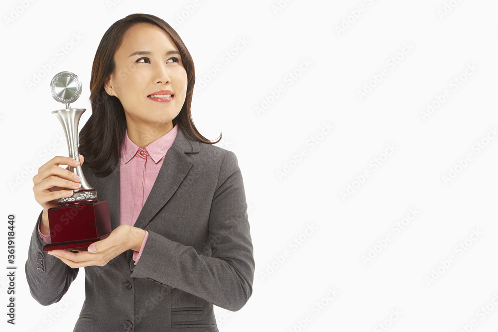 Businesswoman holding a trophy Businesswoman holding a trophy
