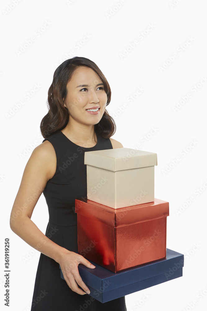 Cheerful woman carrying a stack of gift boxes Cheerful woman carrying a stack of gift boxes