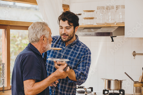 Bild auf Leinwand Elder care from young man to stay home and cooking together with family activity