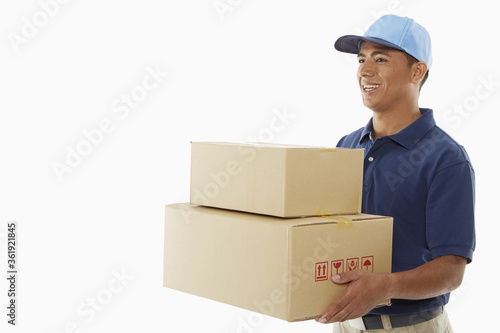Delivery person carrying cardboard boxes © ImageHit