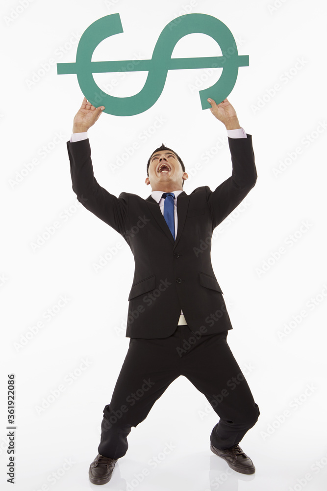 Businessman lifting up a dollar sign Businessman lifting up a dollar sign