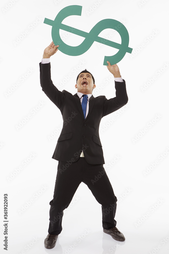 Businessman lifting up a dollar sign