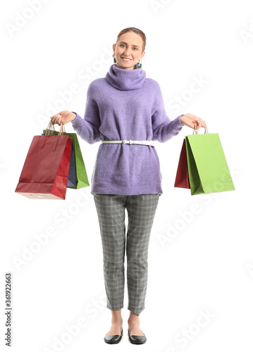 Beautiful young woman with shopping bags on white background