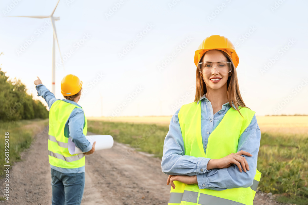 Female engineer on windmill farm for electric power production Female engineer on windmill farm for electric power production