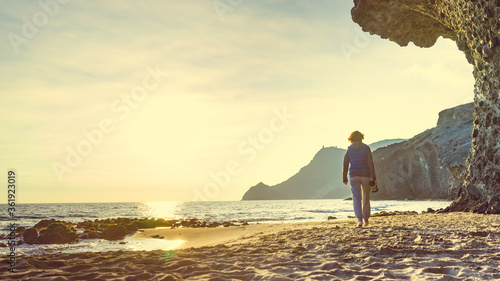 Woman with camera on Monsul beach, Spain