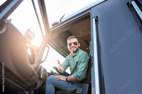 Young driver in cabin of bi...