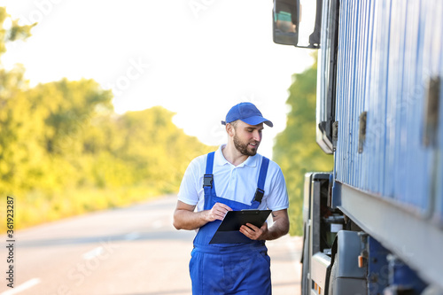 Male driver near big truck ...
