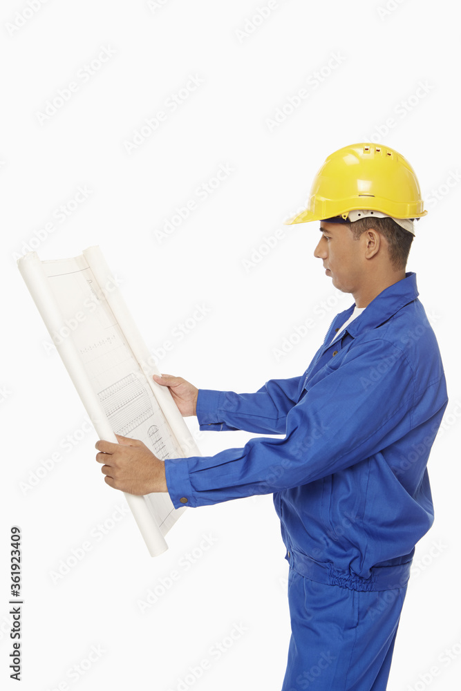 Construction worker looking at a blueprint plan Construction worker looking at a blueprint plan