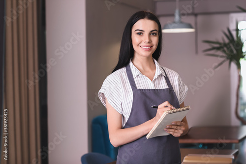 Young waitress with noteboo...