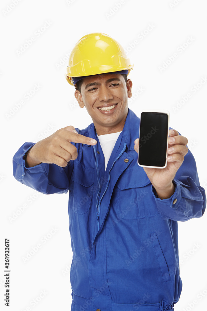 Construction worker holding up a mobile phone Construction worker holding up a mobile phone