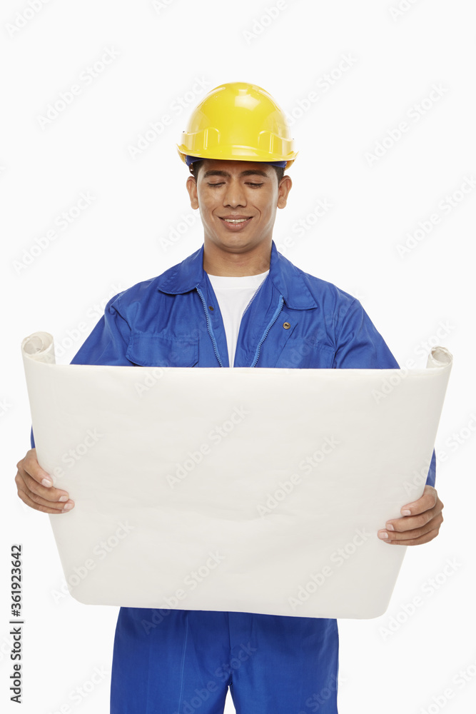 Construction worker looking at a blueprint plan Construction worker looking at a blueprint plan