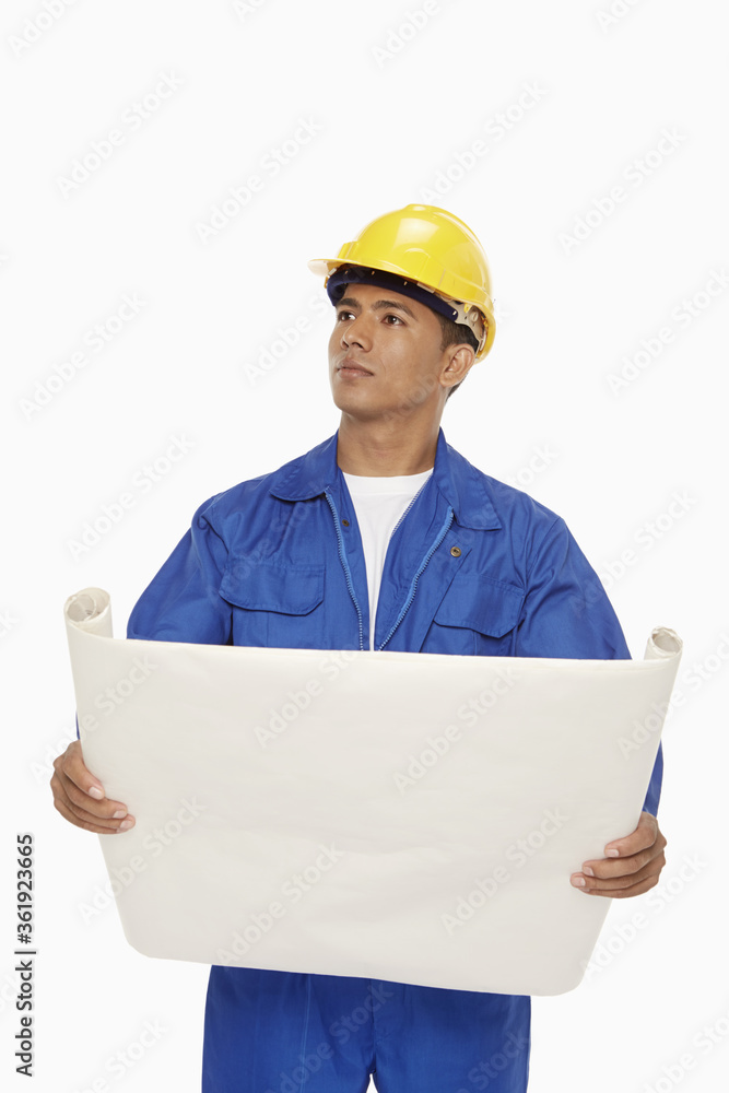 Construction worker looking at a blueprint plan Construction worker looking at a blueprint plan
