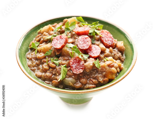 Bowl of tasty lentils soup on white background