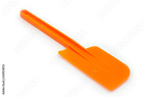 Orange plastic spatula on a white background