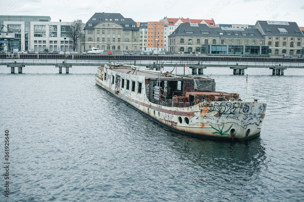 Berlino aspetta la tempesta. Veduta sul fiume con barca abbandonata.