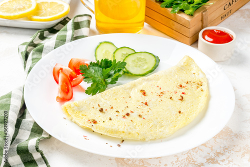 Breakfast omelet with vegetables on a white, round plate
