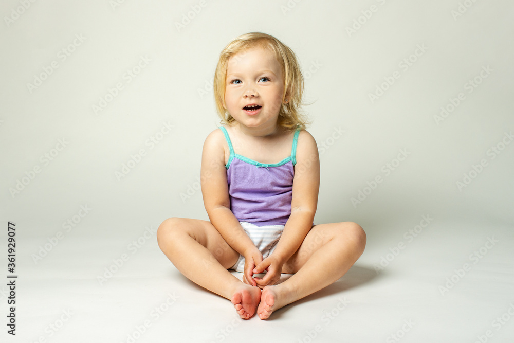 Beautiful cute little baby in a tank top and panties on a white background Beautiful cute little baby in a tank top and panties on a white background