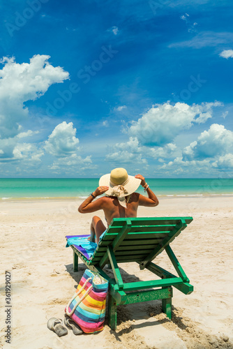 Fototapeta Naklejka Na Ścianę i Meble -  Woman on a sun lounger at the white sand tropical beach