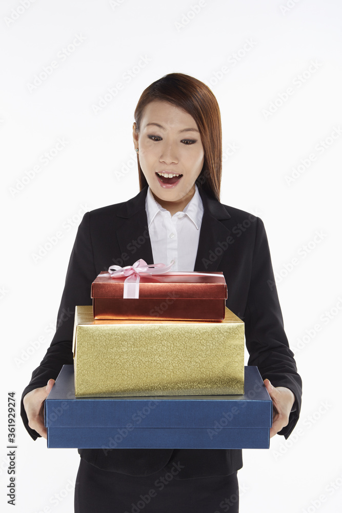 Businesswoman carrying a stack of gift boxes Businesswoman carrying a stack of gift boxes