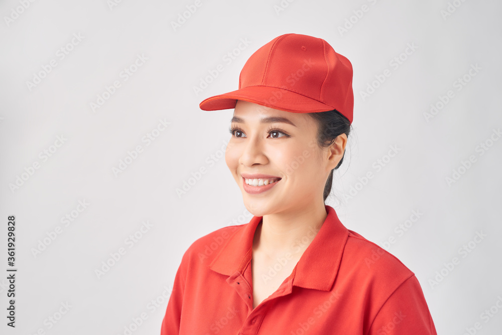 Smiling delivery woman in red uniform standing with arm crossed - isolated on white background Smiling delivery woman in red uniform standing with arm crossed - isolated on white background