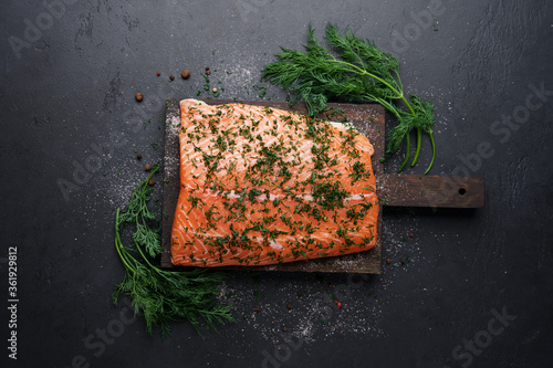 Cooking traditional Scandinavian salted salmon gravlax. Fish fillet with dill, salt and spices photo