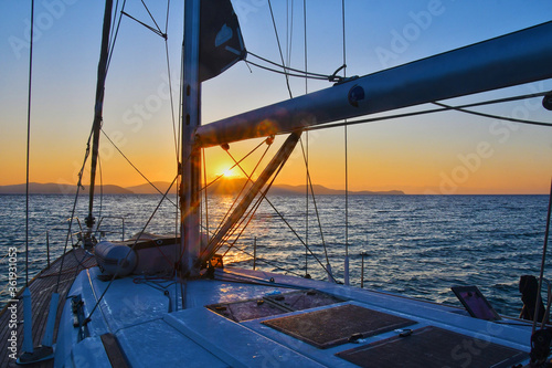 Sailing boat anchored in the ocean at sunset