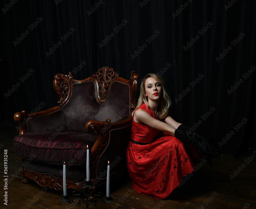 young and beautiful girl in a red dress and a brown armchair