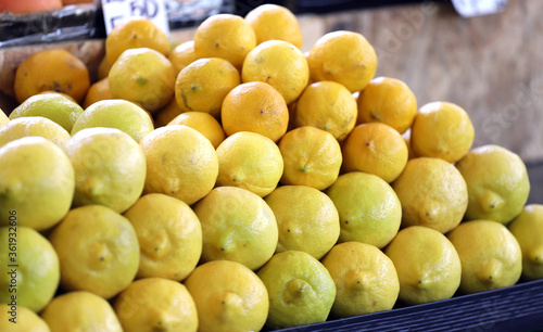Fresh organic yellow lemons on pile on a market. Fruits pattern.