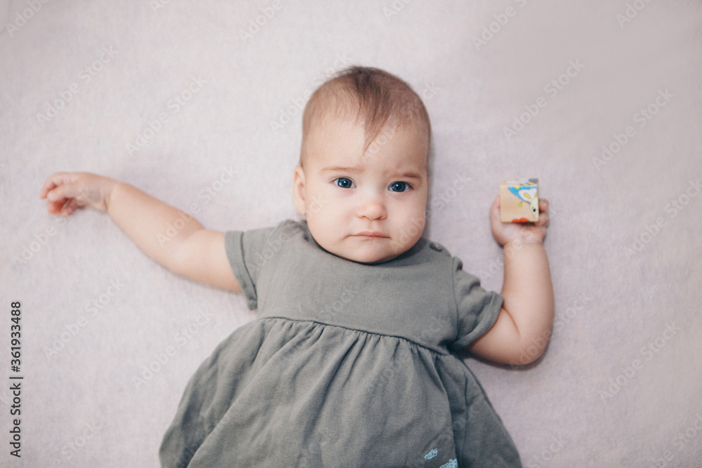 Naklejka premium portrait of a child with a child's cube. the girl is playing. Concept of fine motor skills development, educational games, childhood, children's day, kindergarten copyspace