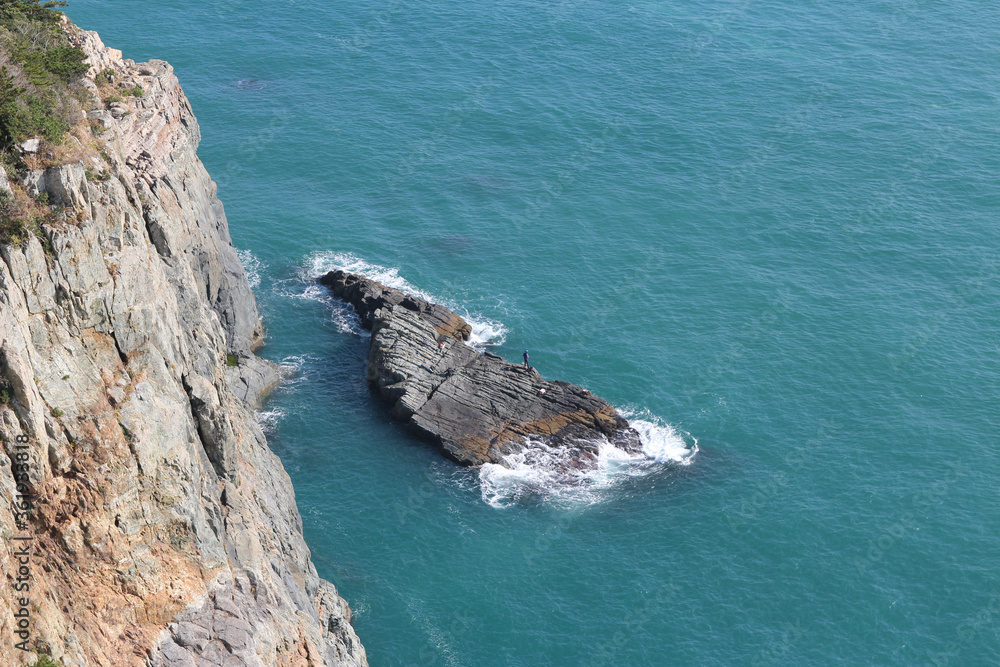 Magnificent cliffs and people fishing on the big rock at Taejongdae recreational park, Busan, South Korea