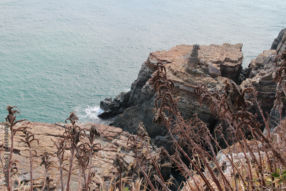 View of Sinseon Rock, rocky and steep cliff, ocean and grass as foreground at the Taejongdae Resort Park in autumn, Busan, South Korea