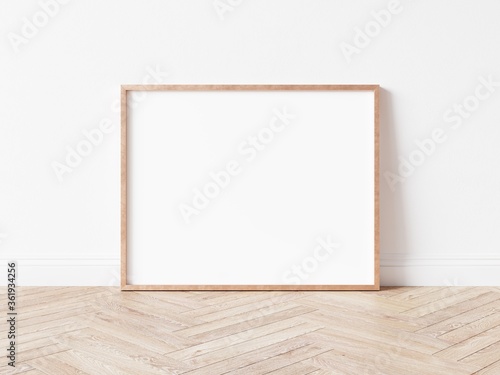 Horizontal rose gold empty frame on wooden floor. Copper frame mock up. 3D illustration.