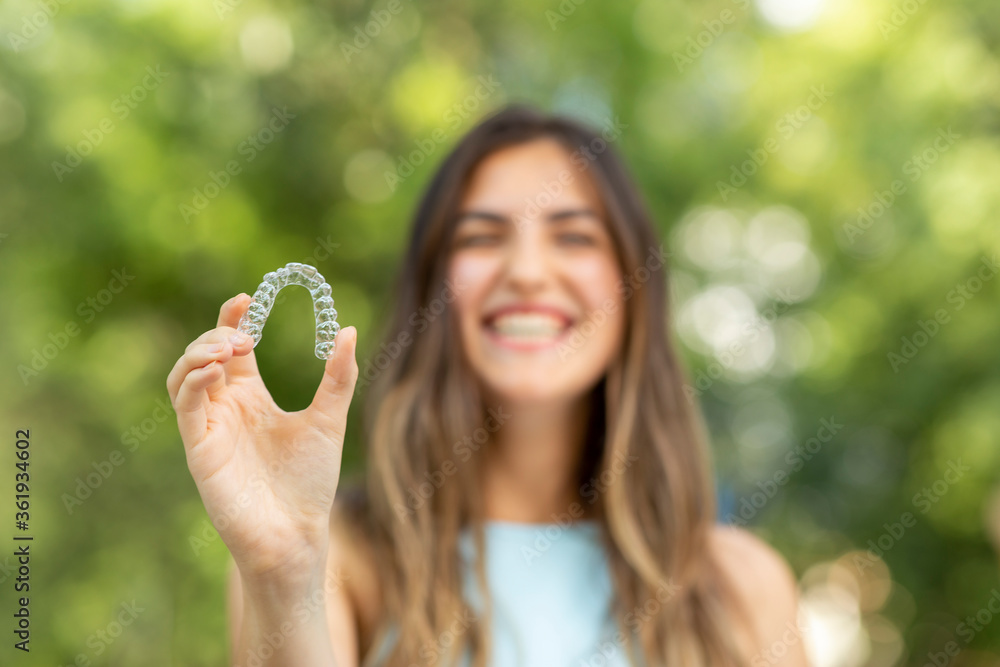 custom made wallpaper toronto digitalBeautiful smiling Turkish woman is holding an invisalign bracer