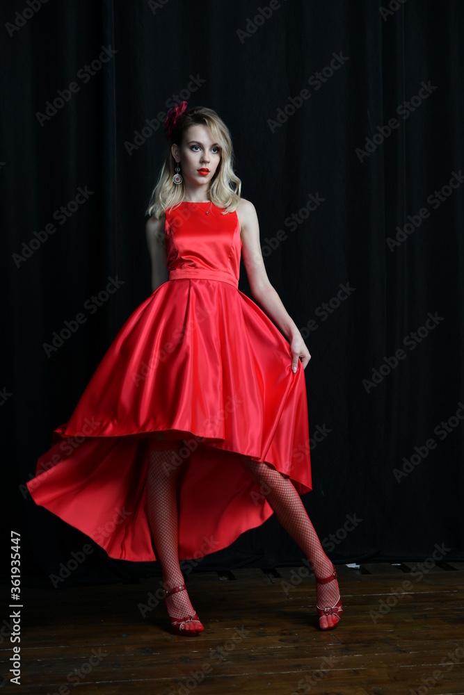 young and beautiful girl tries on her first evening red dress